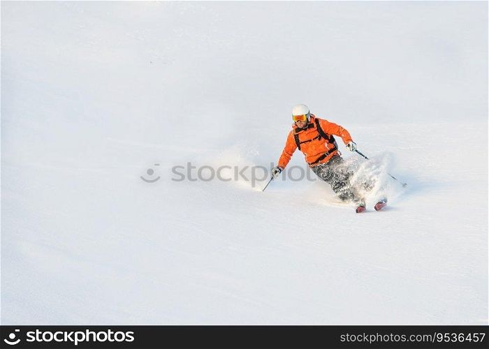 After seal skin ascent a skier has fun in powder snow