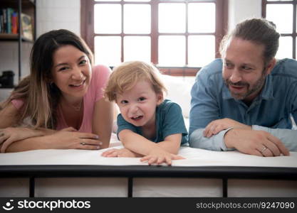 After the little boy wakes up from his nap, his father and mother engage in enjoyable activities in his bedroom.