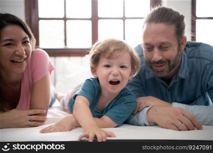 After the little boy wakes up from his nap, his father and mother engage in enjoyable activities in his bedroom.