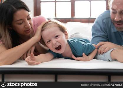 After the little boy wakes up from his nap, his father and mother engage in enjoyable activities in his bedroom.