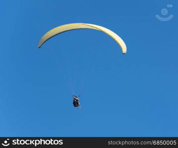 Against the background of the blue sky plan paragliding athletes