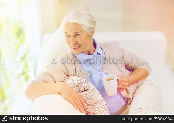 age, drink and people concept - happy smiling senior woman with cup of tea at home. happy senior woman with cup of tea at home. happy senior woman with cup of tea at home