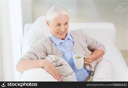 age, drink and people concept - happy smiling senior woman with cup of tea at home