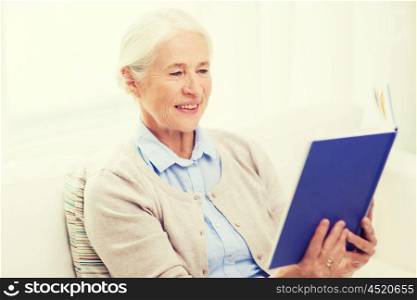 age, leisure and people concept - happy smiling senior woman reading book at home