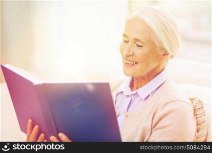 age, leisure and people concept - happy smiling senior woman reading book at home. happy smiling senior woman reading book at home. happy smiling senior woman reading book at home