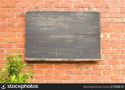 Aged blackboard on red brick wall. concept of education.