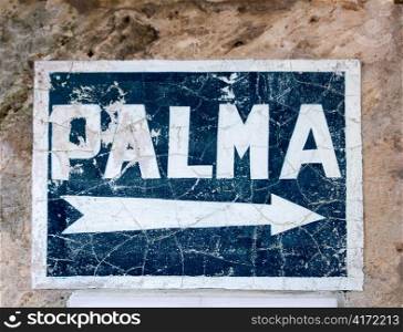 Aged blue road sign with arrow to Palma de Majorca hand painted