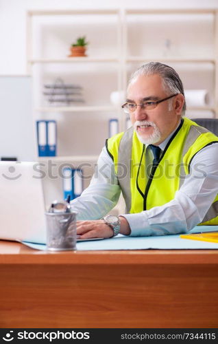 Aged construction engineer working in the office 