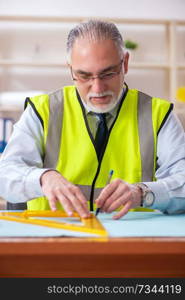 Aged construction engineer working in the office 