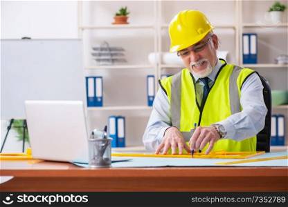 Aged construction engineer working in the office 