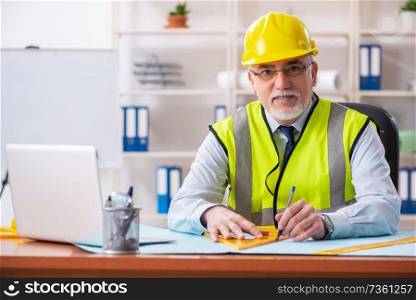 Aged construction engineer working in the office 