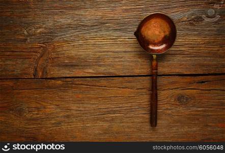 Aged cooper ladle vintage on wooden table retro
