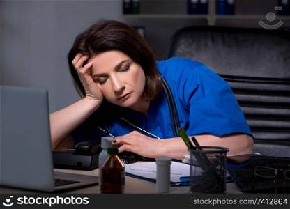 Aged female doctor working at night shift 