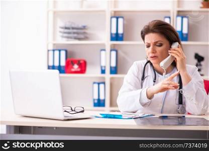 Aged female doctor working in the clinic 