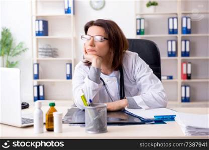 Aged female doctor working in the clinic 