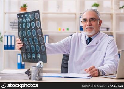 Aged male doctor radiologist in the clinic 