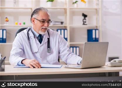 Aged male doctor working in the clinic 
