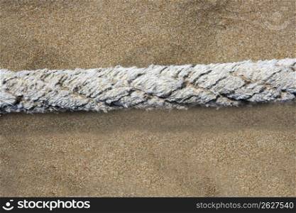 aged marine weathered rope over beach sand background summertime