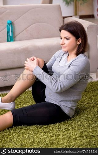 Aged pregnant woman doing exercises at home 