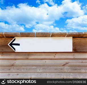 aged wood arrow direction sign on summer blue sky