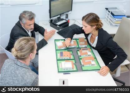 agent and couple discussing real estate contract top view