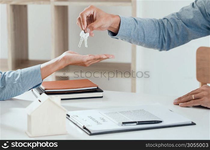 agent giving house keys to customer after sign agreement property, concerning mortgage loan offer for and house insurance
