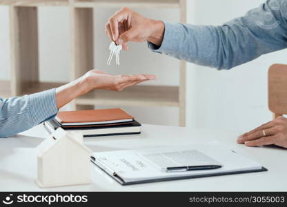 agent giving house keys to customer after sign agreement property, concerning mortgage loan offer for and house insurance