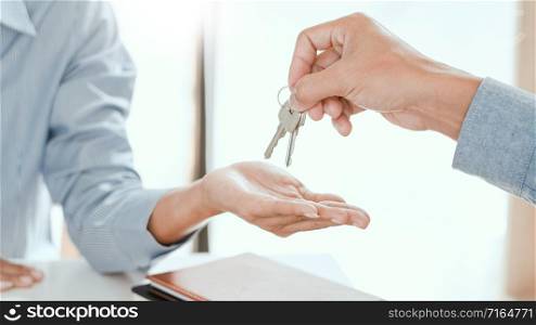 agent giving house keys to customer after sign agreement property, concerning mortgage loan offer for and house insurance