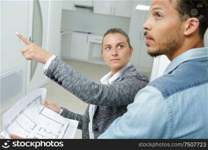 agent pointing out detail to client visiting property