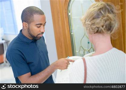 agent with documents and potential client talking near door