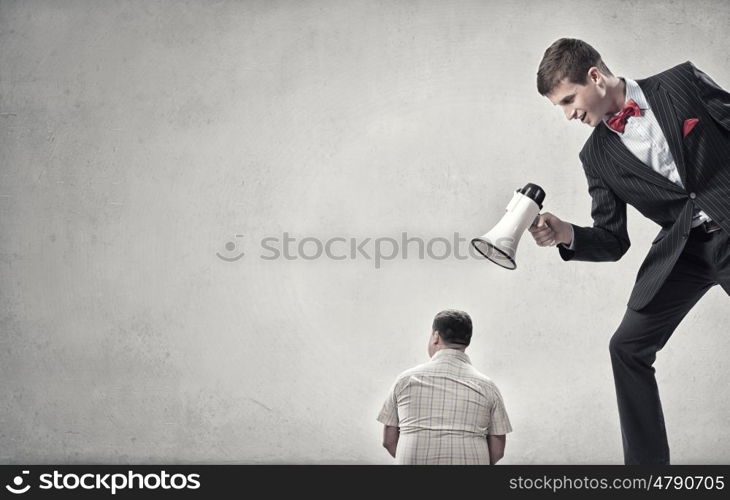 Aggression and humiliation in communication. Aggressive businessman screaming in megaphone on his colleague