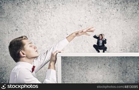 Aggressive boss. Angry businessman screaming at miniature of man colleague