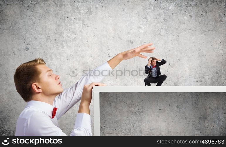 Aggressive boss. Angry businessman screaming at miniature of man colleague