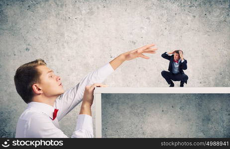 Aggressive boss. Angry businessman screaming at miniature of man colleague