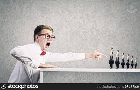 Aggressive boss. Angry businessman screaming at miniature of woman colleague