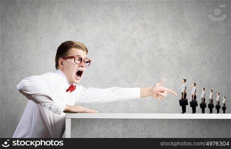 Aggressive boss. Angry businessman screaming at miniature of woman colleague