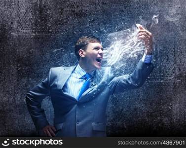Aggressive business. Angry businessman screaming furiously in to mobile phone