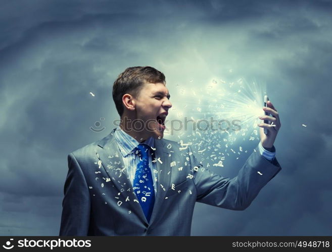 Aggressive business. Angry businessman screaming furiously in to mobile phone