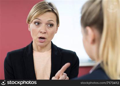 Aggressive Businesswoman Shouting At Female Colleague