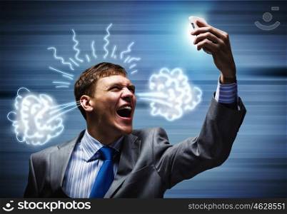 Aggressive management. Angry businessman screaming furiously in mobile phone