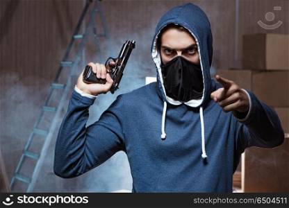 Aggressive manwith gun wearing face mask