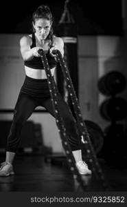 Agility training, woman exercising with rope in a gym. 