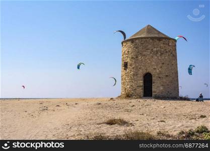 Agios Ioannis beach in Lefkas island Greece. Agios Ioannis beach in Lefkas island Greece. Colorful power kites span across the sky from kite-surfers. Agios Ioannis is home to some old windmills.