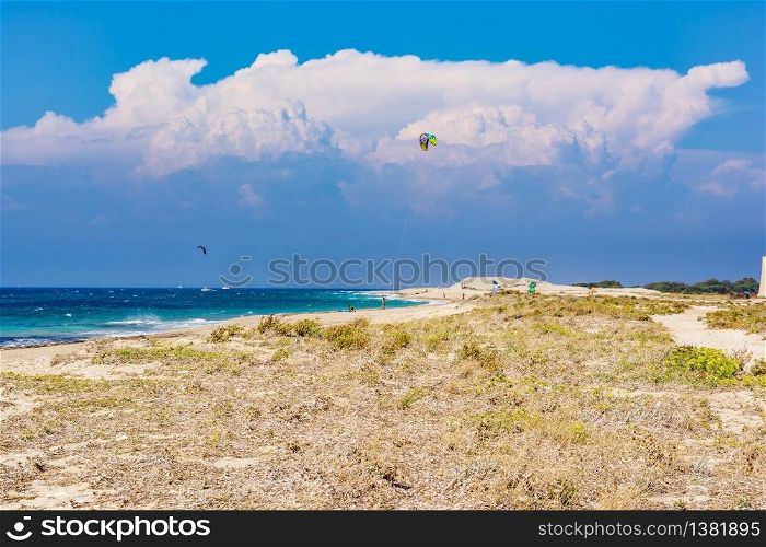 Agios Ioannis beach in Lefkas island Greece. Colorful power kites span across the sky from kite-surfers.. Agios Ioannis beach in Lefkas island Greece