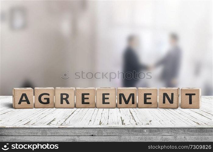 Agreement sing on a word with business men shaking hands in the background