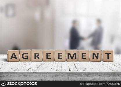 Agreement sing on a word with business men shaking hands in the background