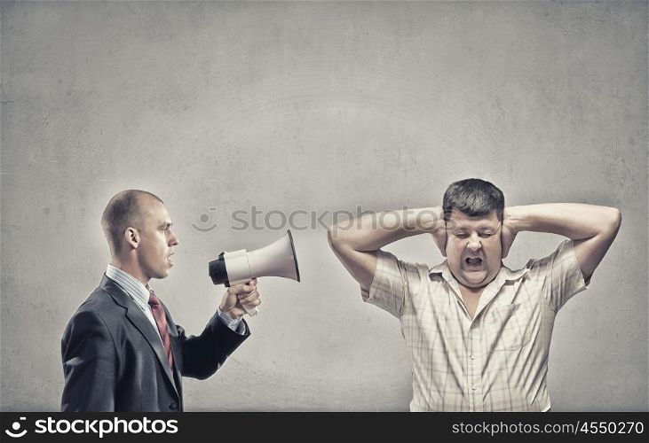 Agression in communication. Furious man screaming agressively in megaphone at man