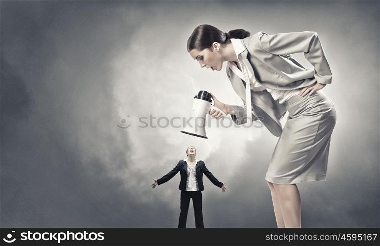 Agression in communication. Furious woman screaming agressively in megaphone at woman