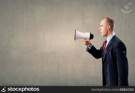 Agressive management. Businessman using megaphone to scream agressively at woman