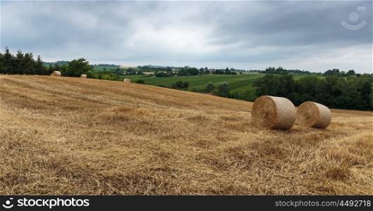 Agricultural field with straw bales after harvestin Italy